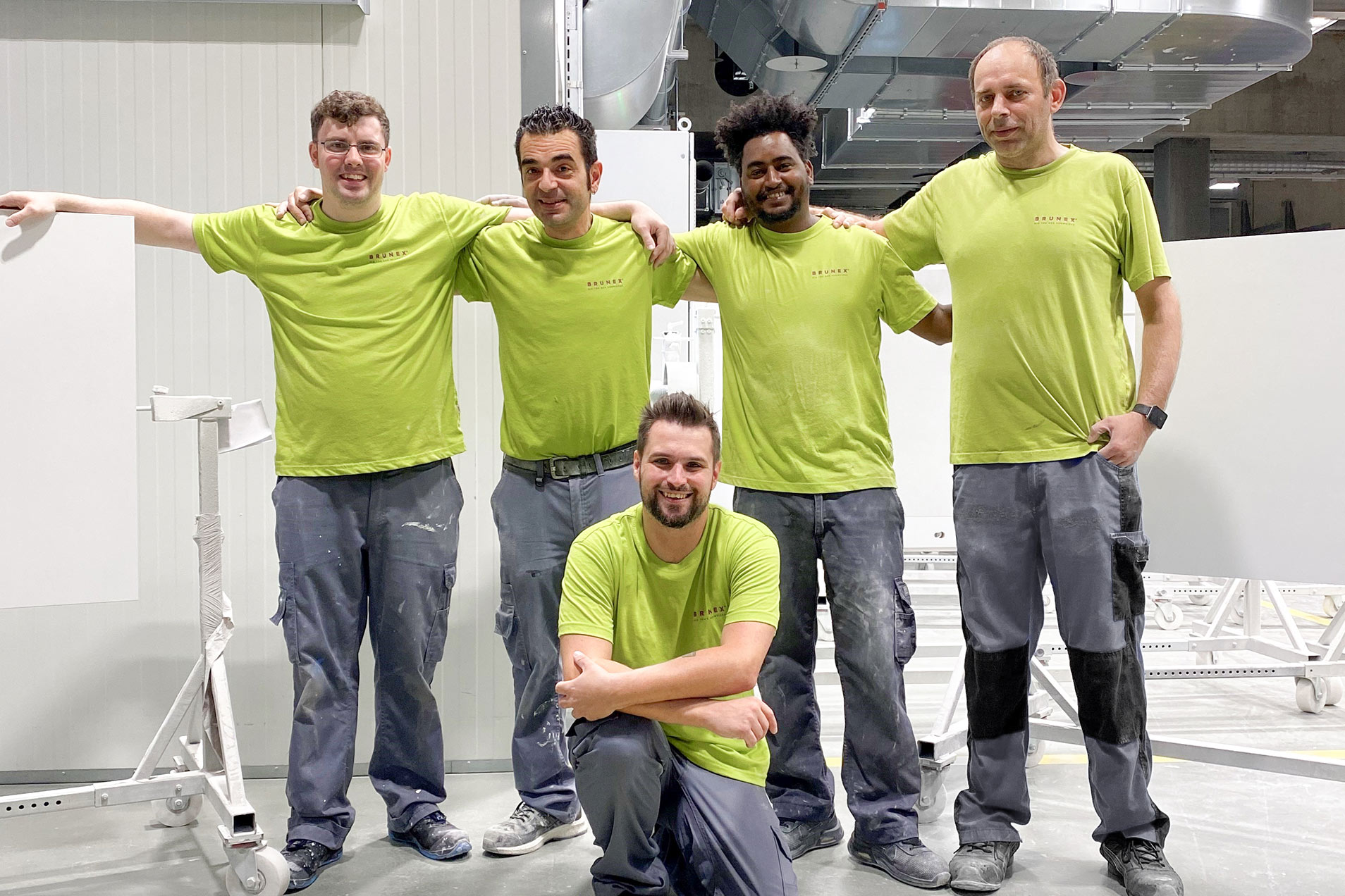 Gruppe von fünf Arbeitern in einem Arbeitsraum.