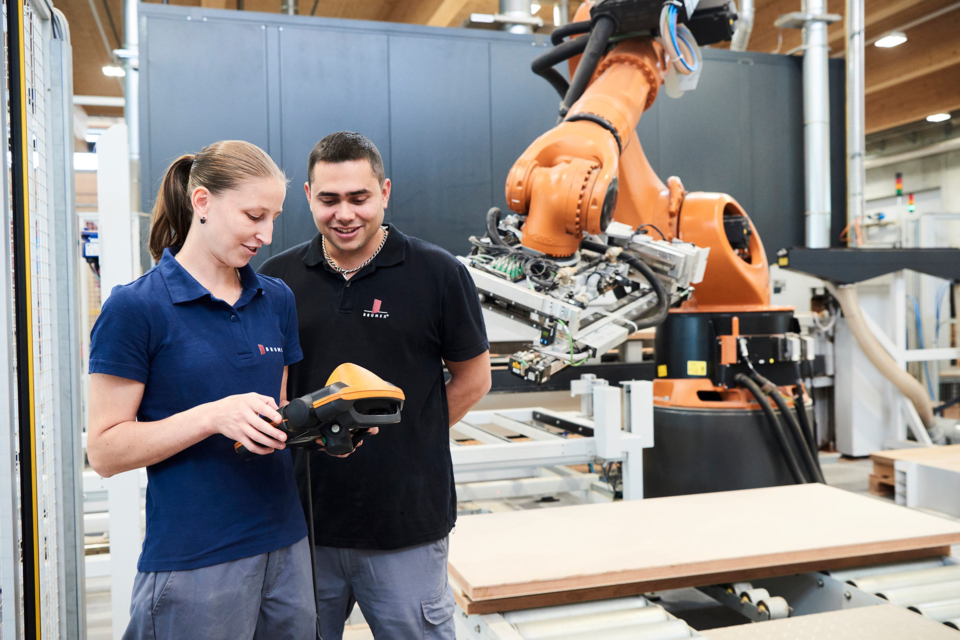 Zwei Arbeiter diskutieren über einen Roboterarm.