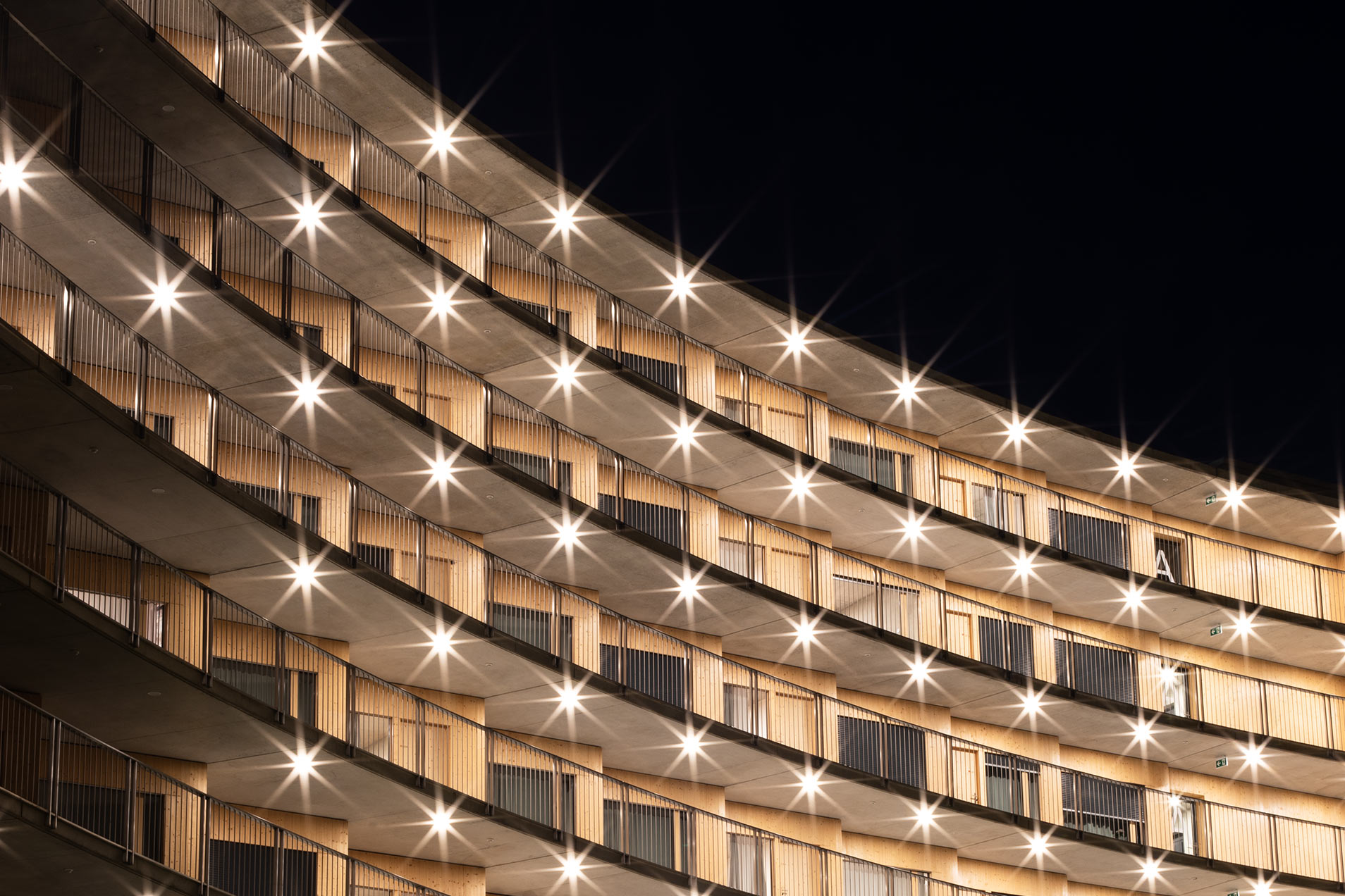 Beleuchtetes Gebäude in urbaner Umgebung bei Nacht.