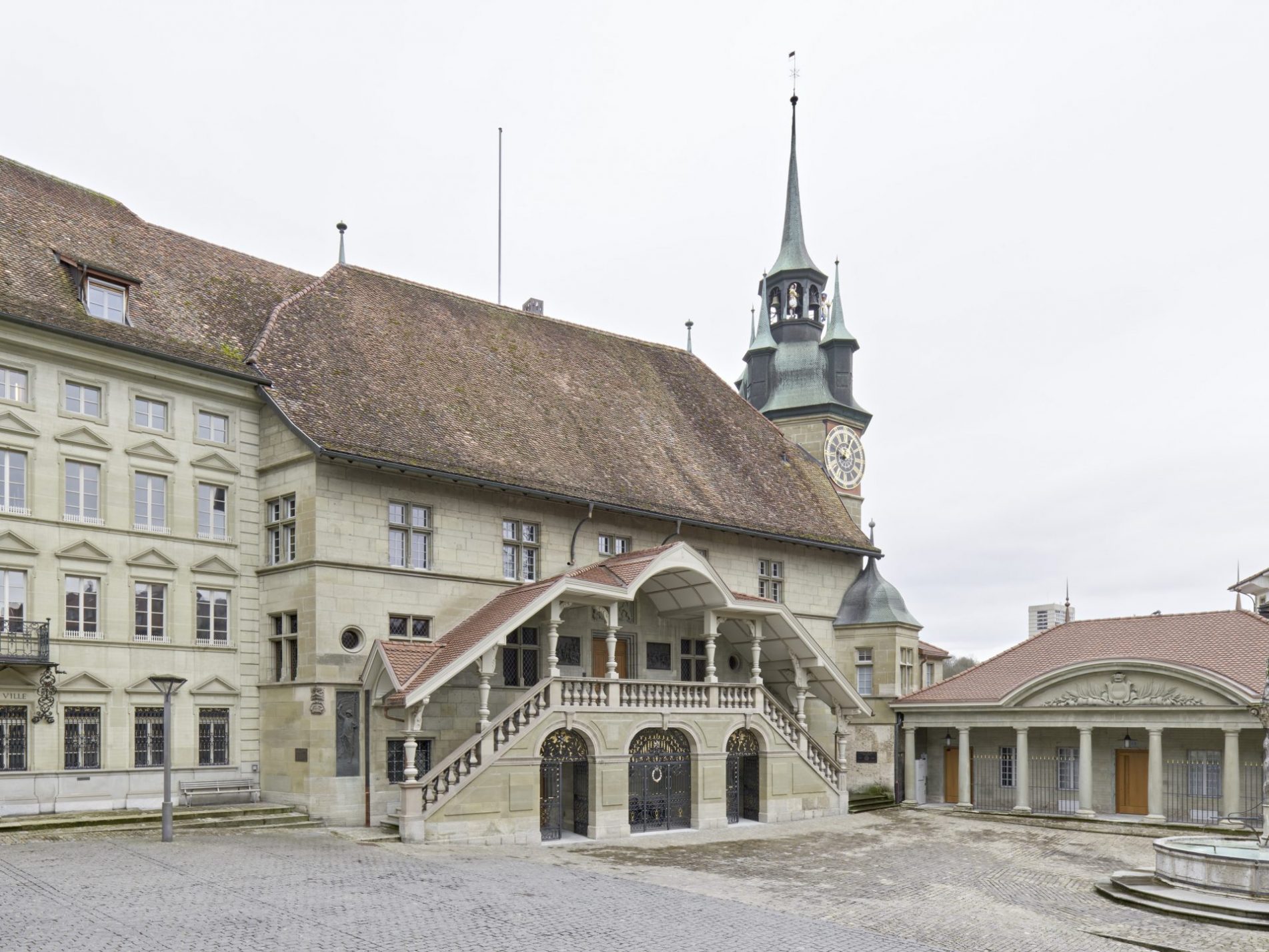 Historisches Gebäude mit einem Uhrturm und Treppen.