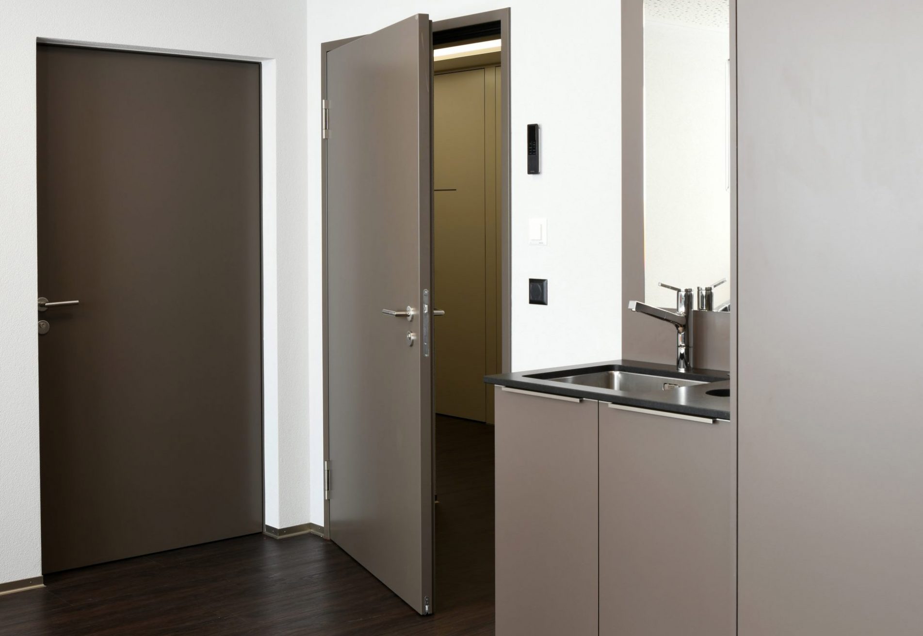 Partial view of a indoor kitchenette with open door.