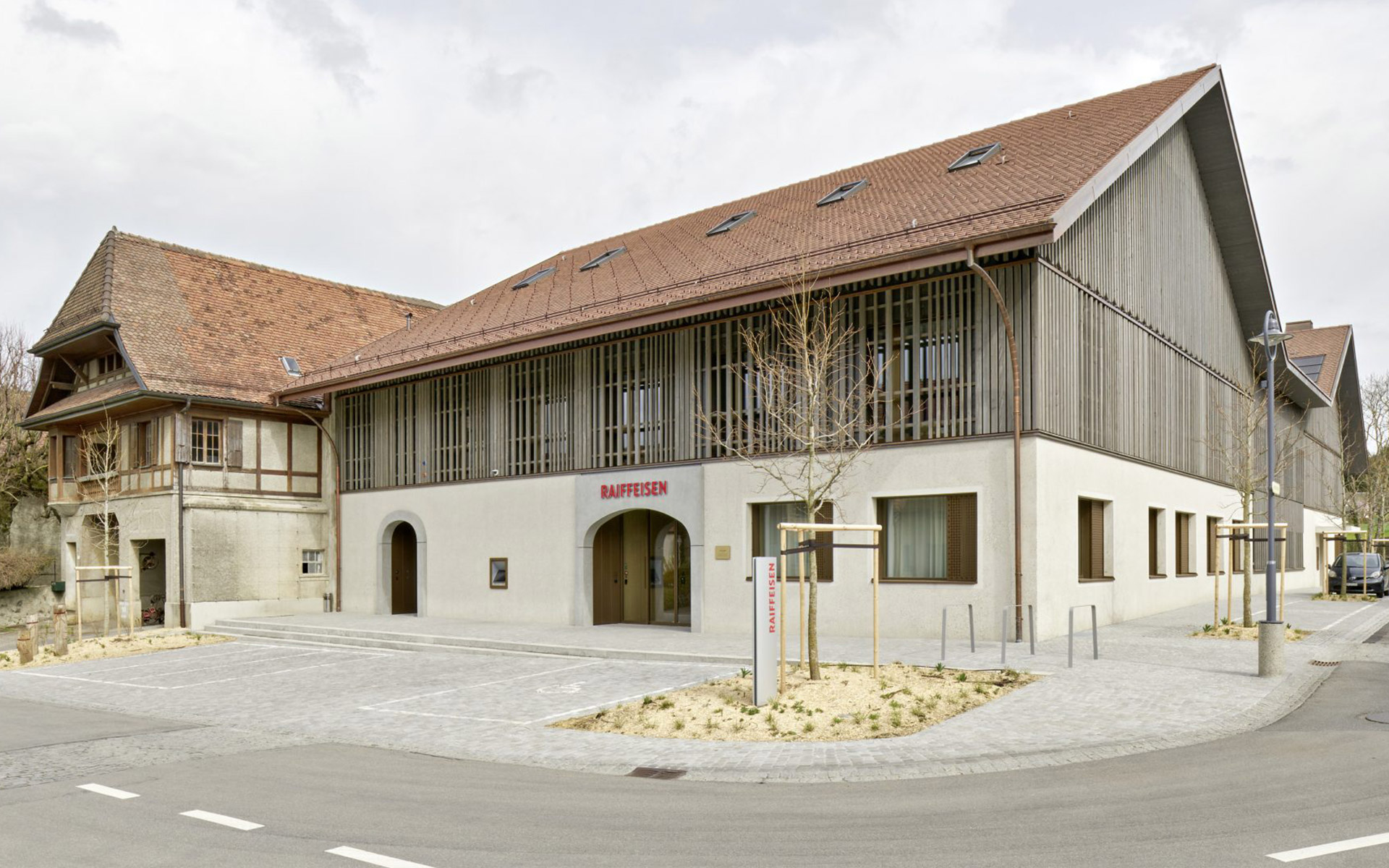 Modernes Gebäude neben traditioneller Struktur.