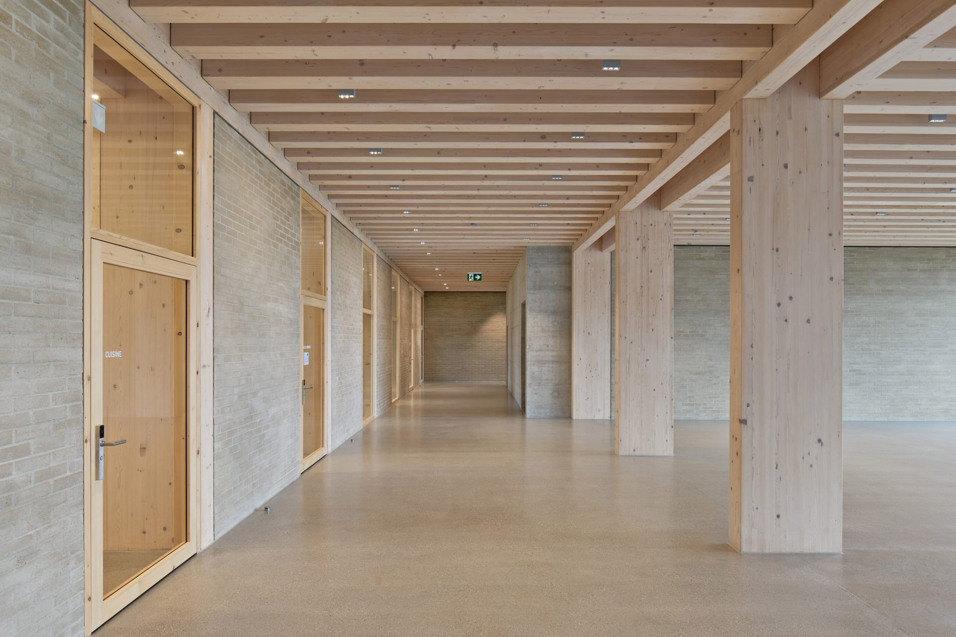 Lichtdurchfluteter Innenhof mit Holz- und Betonkonstruktion.
