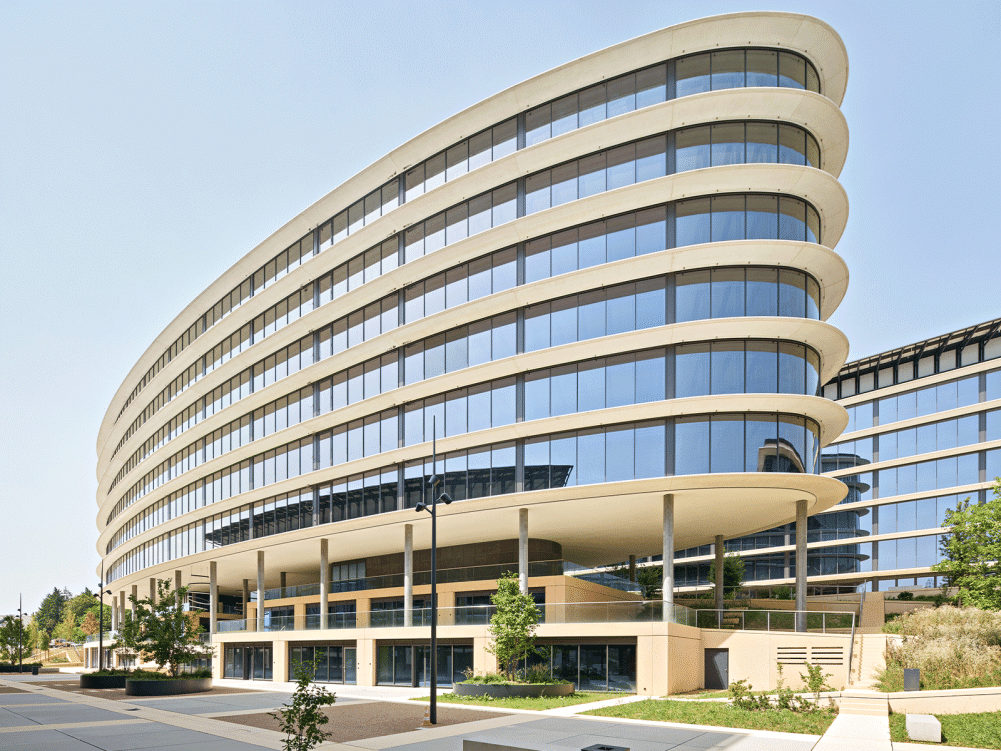 Moderne, gebogene Gebäude mit Glasfenstern.